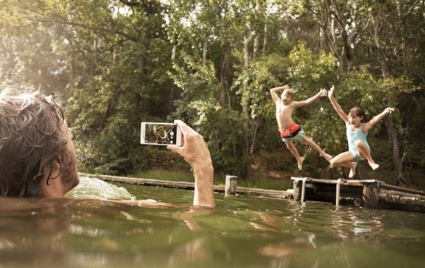 Seseorang menggunakan Xperia M4 Aqua untuk mengambil foto di bawah hujan